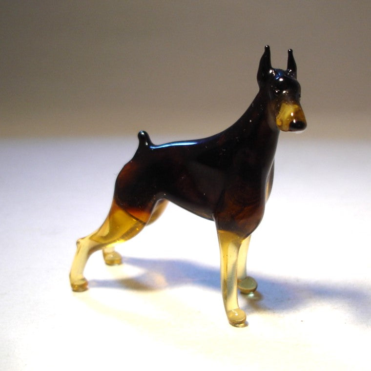 Close-up of the glass Doberman figurine’s head, highlighting its alert expression and pointed sharp ears.