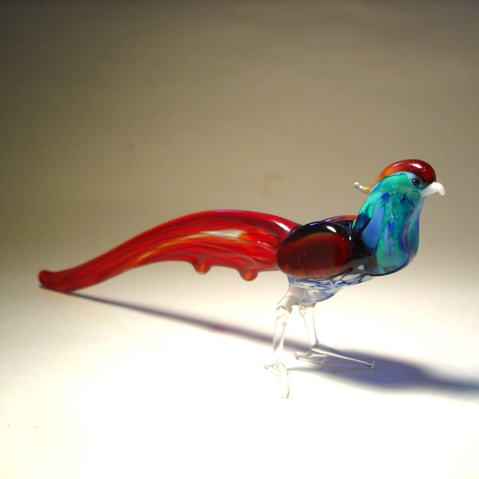 Side angle of the glass pheasant figurine, capturing the elegant curve of its long red tail feathers.
