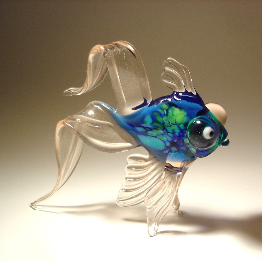Light blue telescope fish with green specs on its body and bulging eyes
