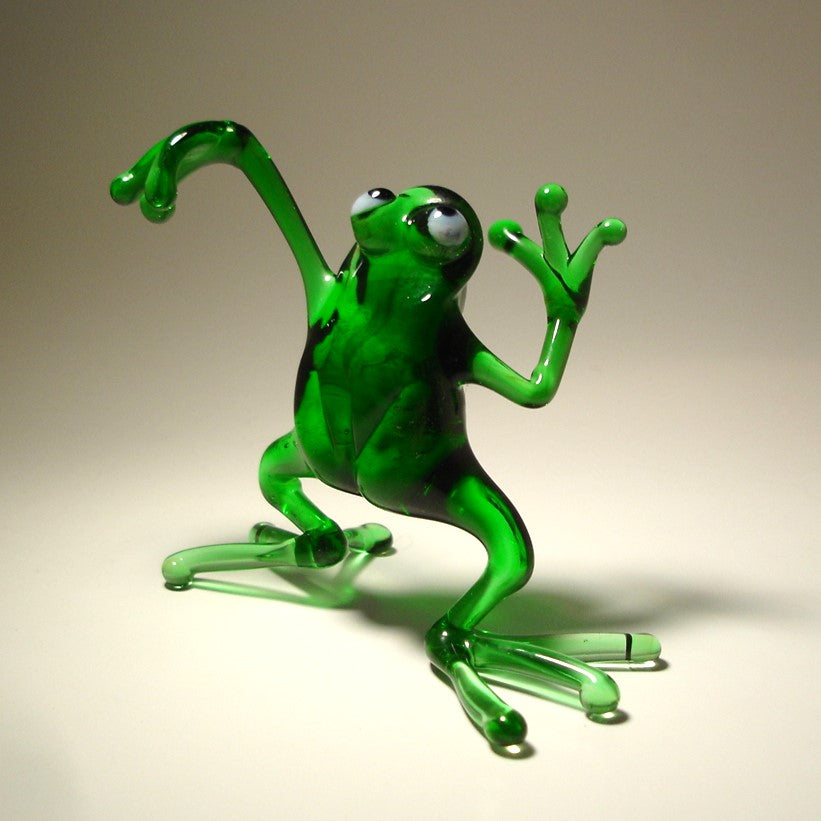 Front view of a glass dancing frog figurine, showing the frog mid-dance with one leg slightly raised and arms extended.