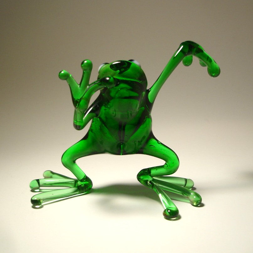 Close-up of the glass dancing frog figurine, focusing on the frog's joyful expression and dynamic dance pose.