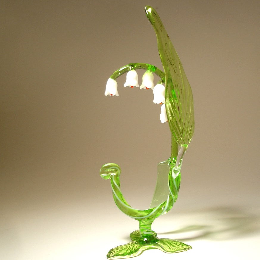 A side view of the glass Lily of the Valley flower figurine, capturing its graceful curves and the arrangement of flowers along the stem.