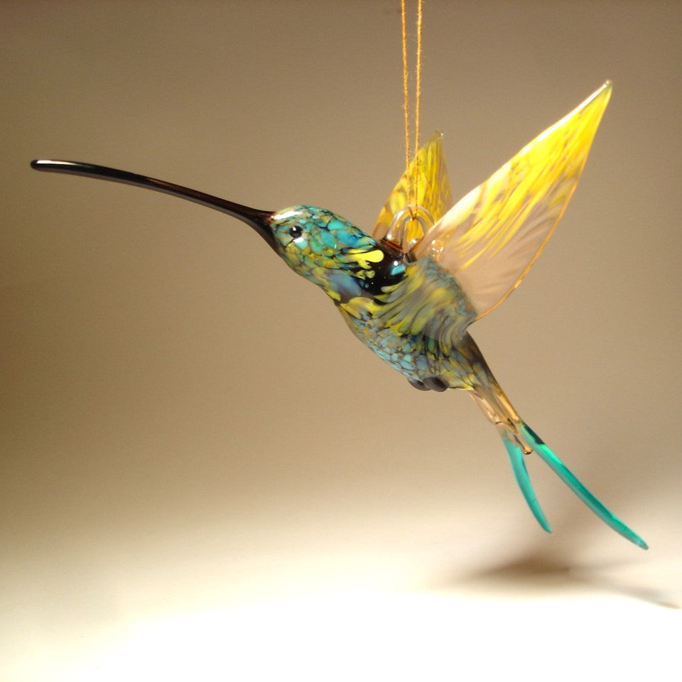 Front view of the swallowtail hummingbird ornament showing the long black beak and a glass hanging hook.