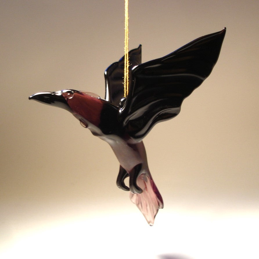 Side view of the glass raven crow figurine, focusing on the fine craftsmanship of its wings and tail feathers.