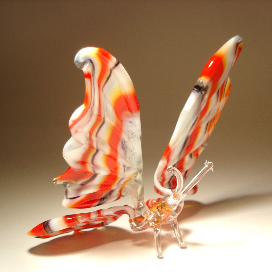 Another side view of a glass butterfly sitting on two delicate legs.