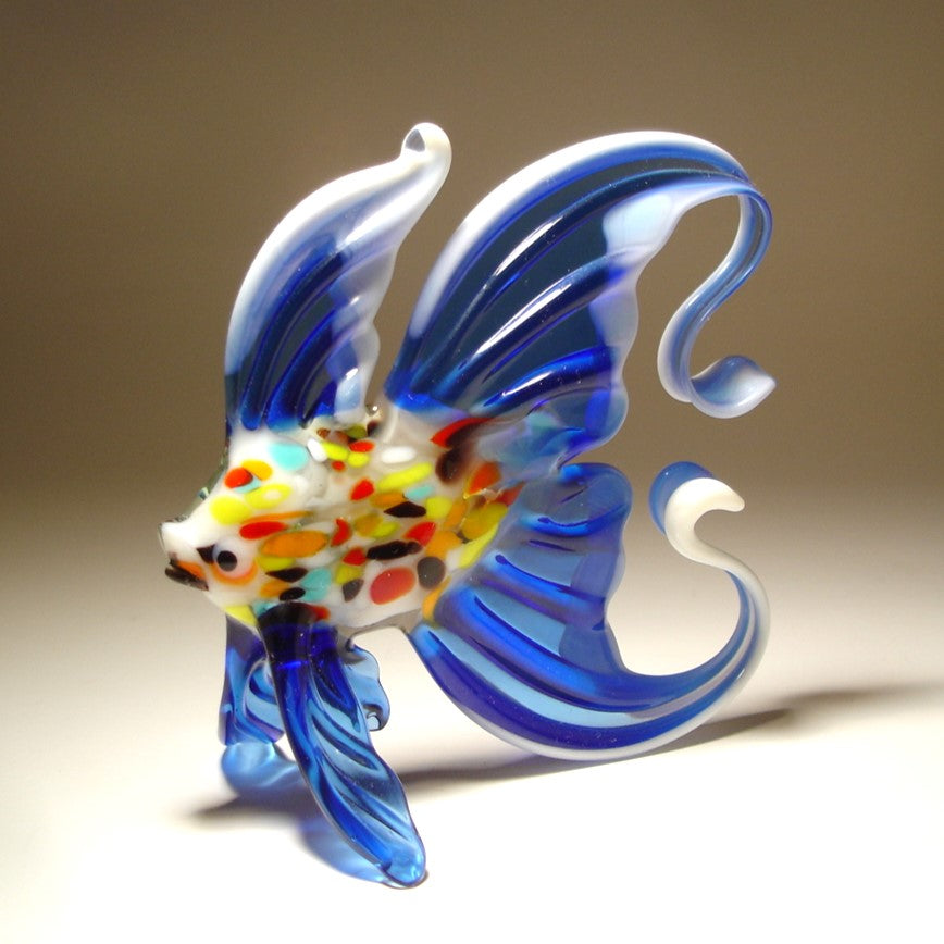 A hand-blown glass fish figurine with vibrant blue, white, yellow, and red details