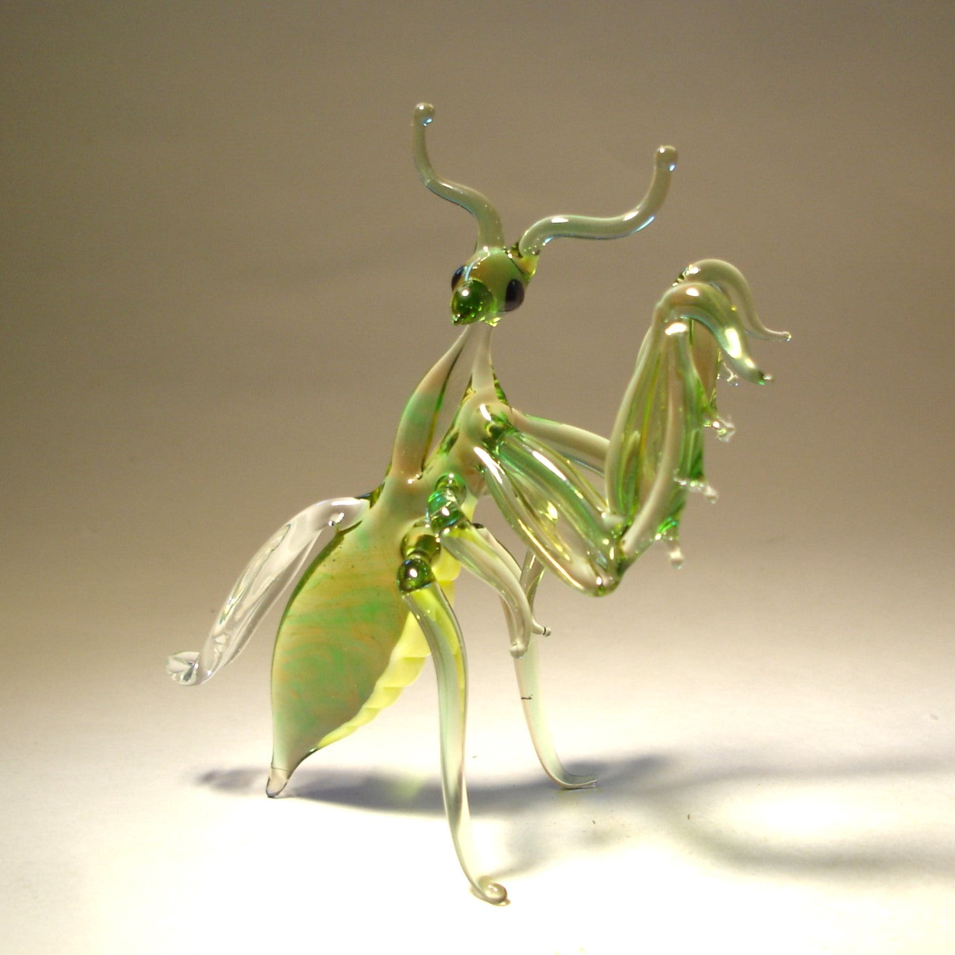 Handmade glass mantis figurine in light green color with yellow belly