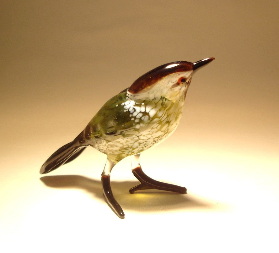 view of the glass Black & White Warbler figurine, focusing on head with a black stripe and mostly white underbelly.