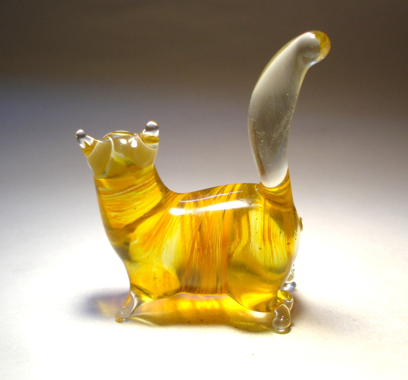 a back view of the glass cat showing its short clear glass legs and upright clear ears.