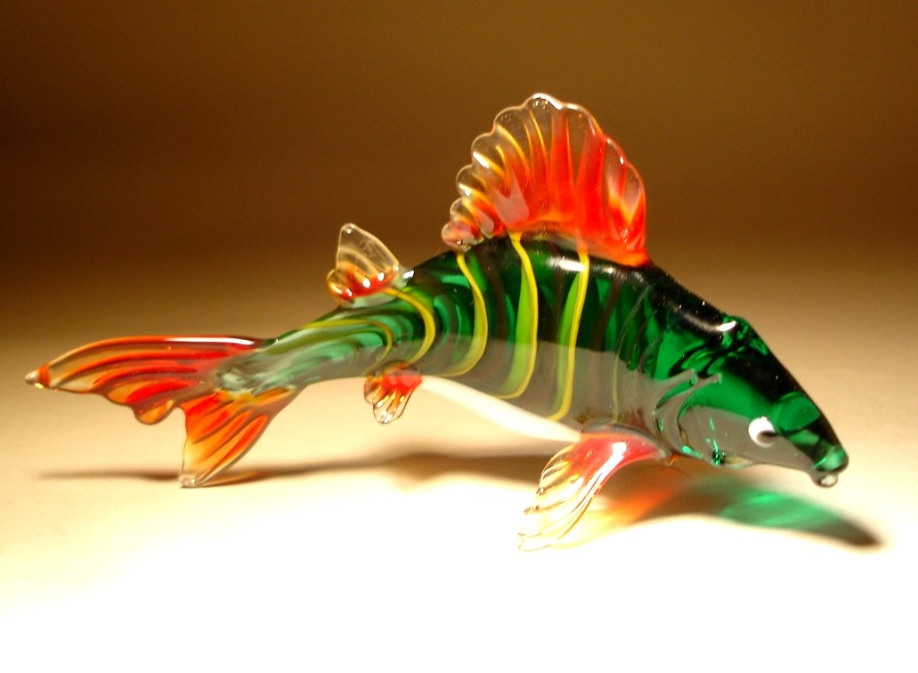 A detailed glass carp figurine with red tail and fins, capturing the fish in a graceful swimming posture.