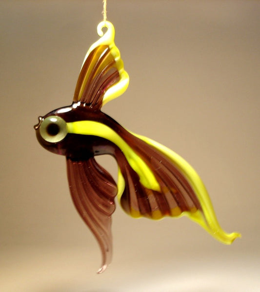 A glass ornament shaped like a telescope fish with a vibrant purple and yellow body, featuring large, exaggerated eyes and flowing fins.