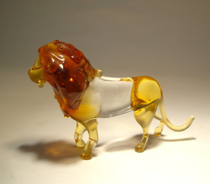 A majestic glass lion figurine depicted in a standing pose, showcasing its detailed mane and fierce expression, reflecting light beautifully.