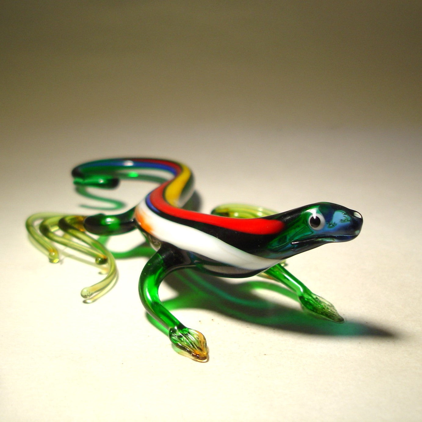 front view of the glass lizard figurine with a raised head looking on