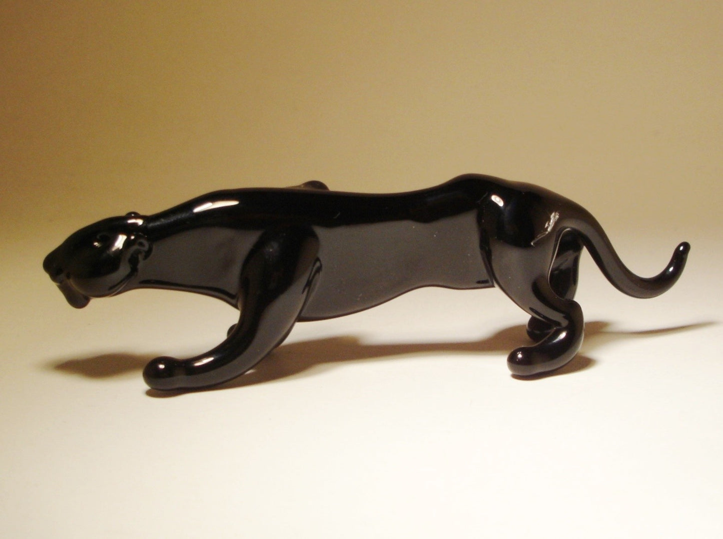 The other side of a black glass panther figurine walking