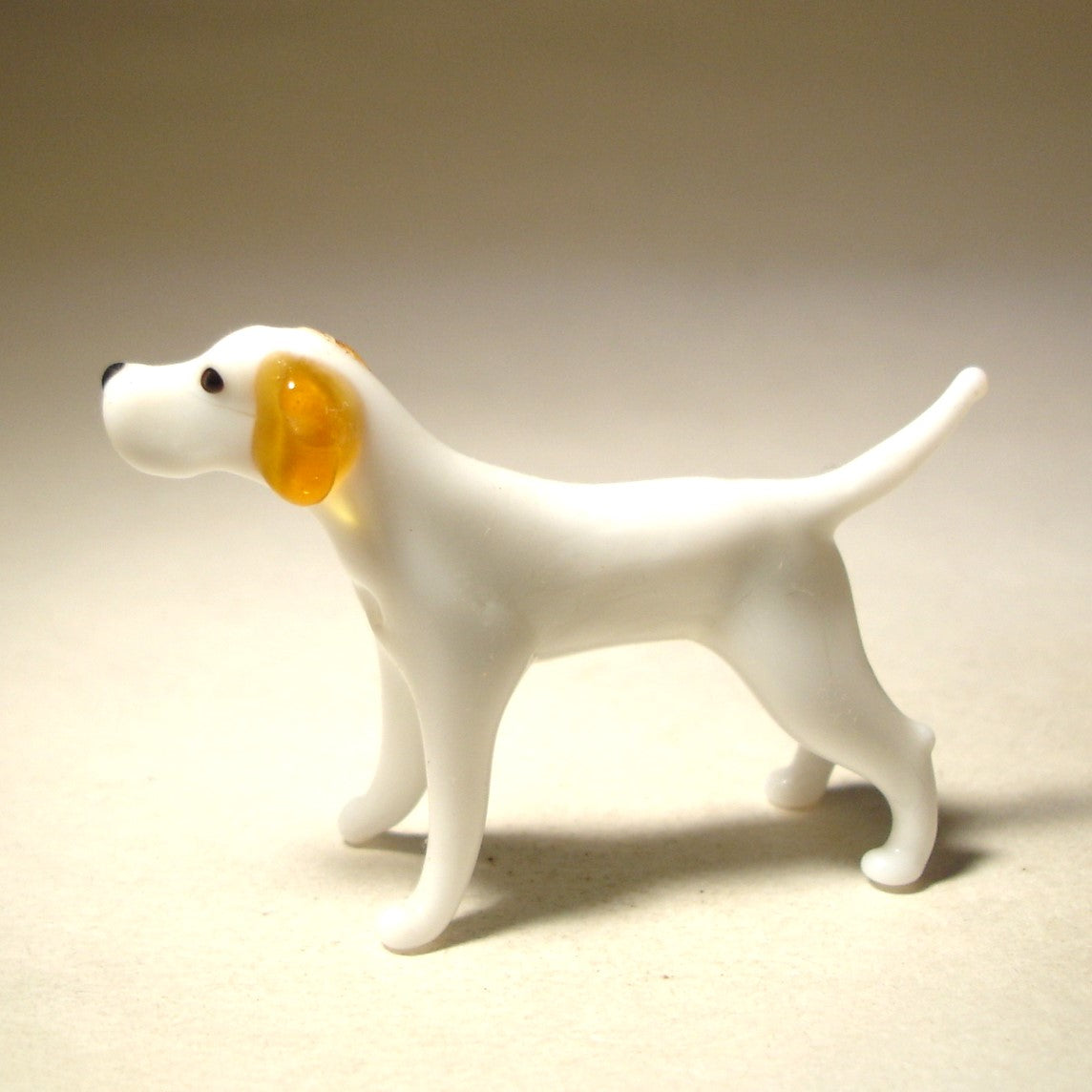 Side view of a glass Great Dane figurine with alert head and tail.