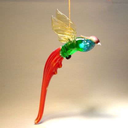 A glass Hanging Bird Pheasant figurine ornament, suspended from a thread, featuring red, blue and green plumage. 