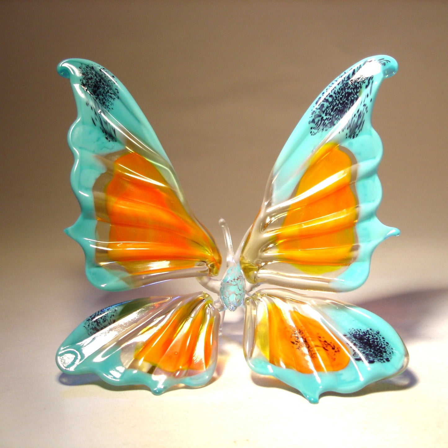 Unique blown glass butterfly figurine in blue and orange colors, perfect as a decorative art piece or meaningful gift