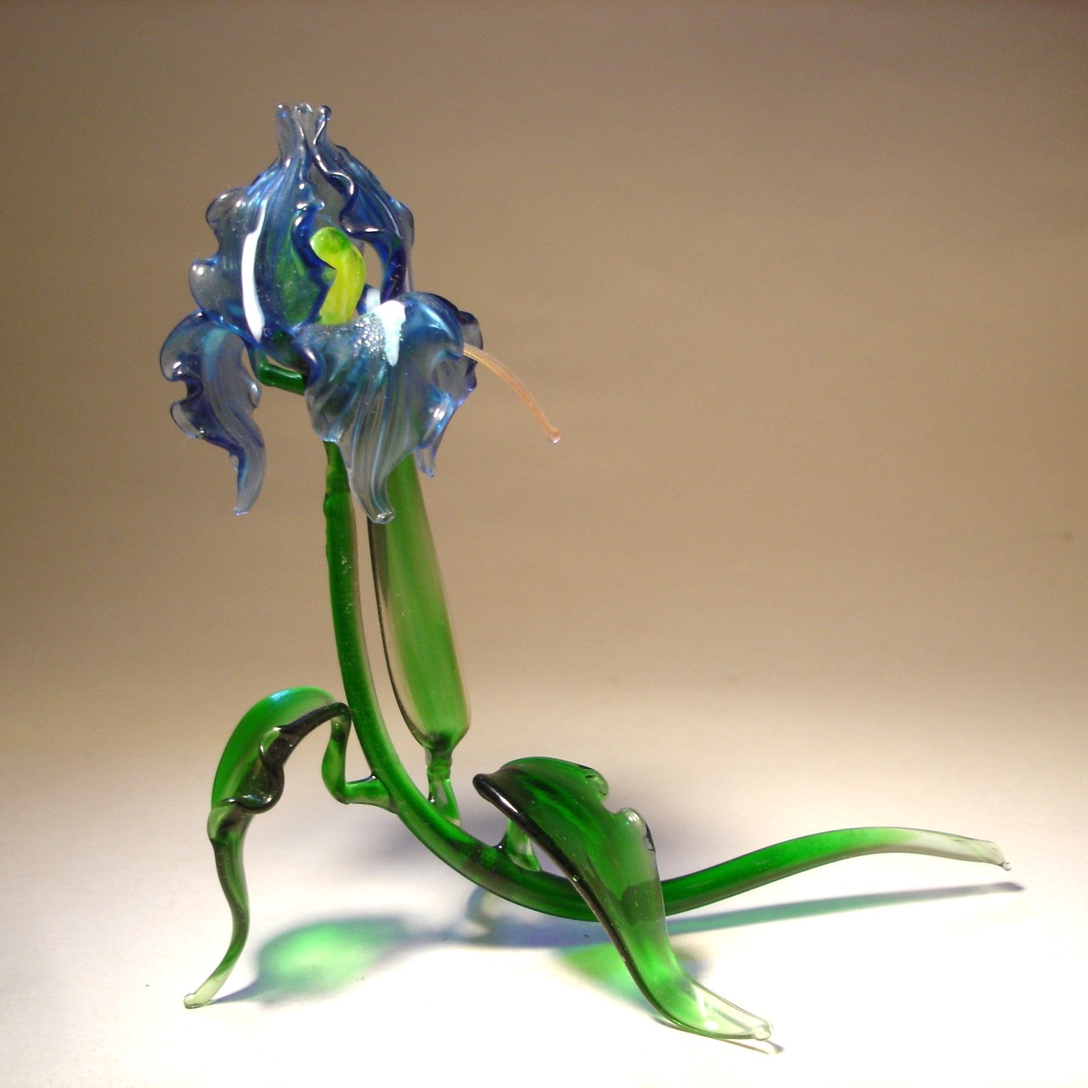 Handmade glass blue iris figurine, with intricate curves of the petals and the natural flow of the leaves.