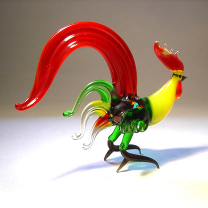 Handmade glass fighter rooster figurine with red and Green tail and yellow neck.