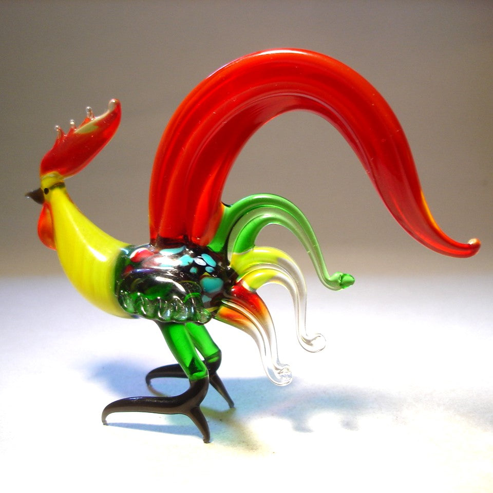 Another side view of a glass red fighter rooster, highlighting its muscular build, intricately crafted feathers, and flowing tail.