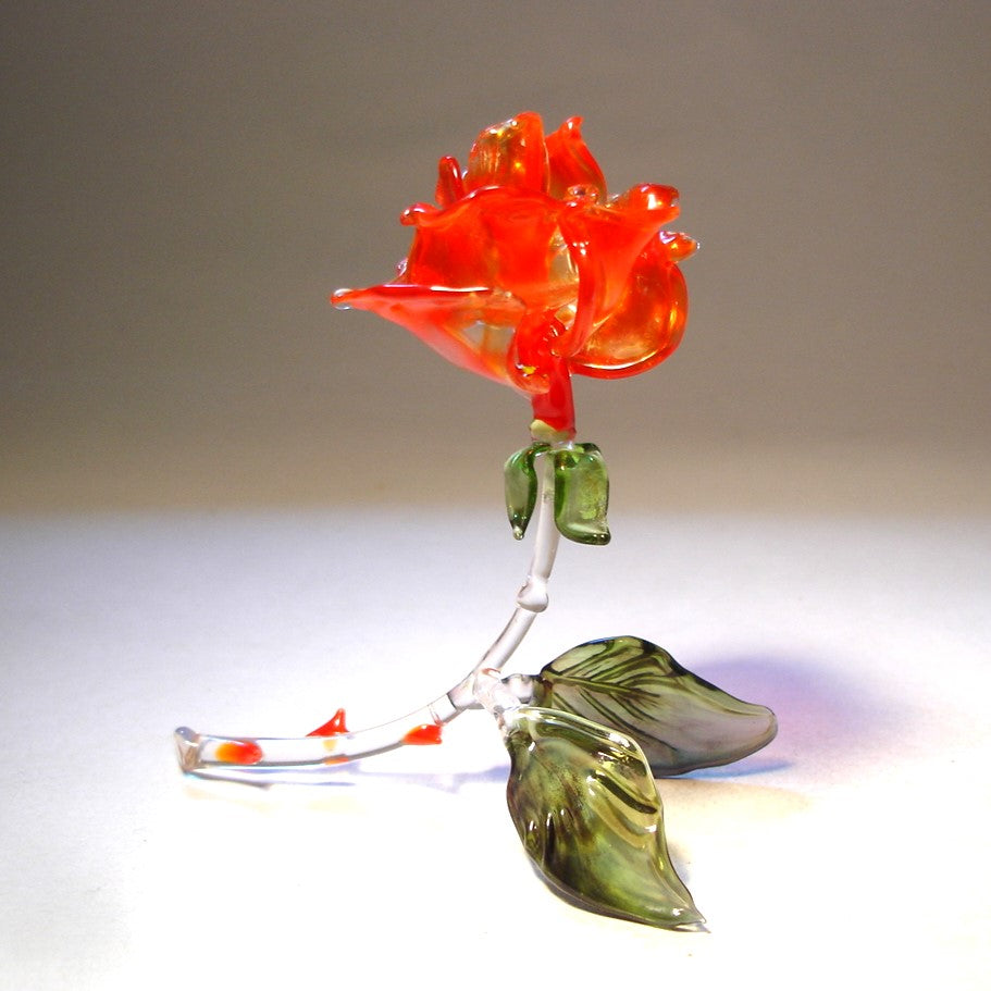 Handcrafted red glass rose figurine  with delicate petals, a curved stem adorned with red glass thorns.