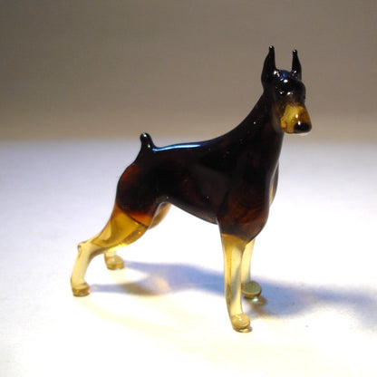 Close-up of the glass Doberman figurine’s head, highlighting its alert expression and pointed sharp ears.