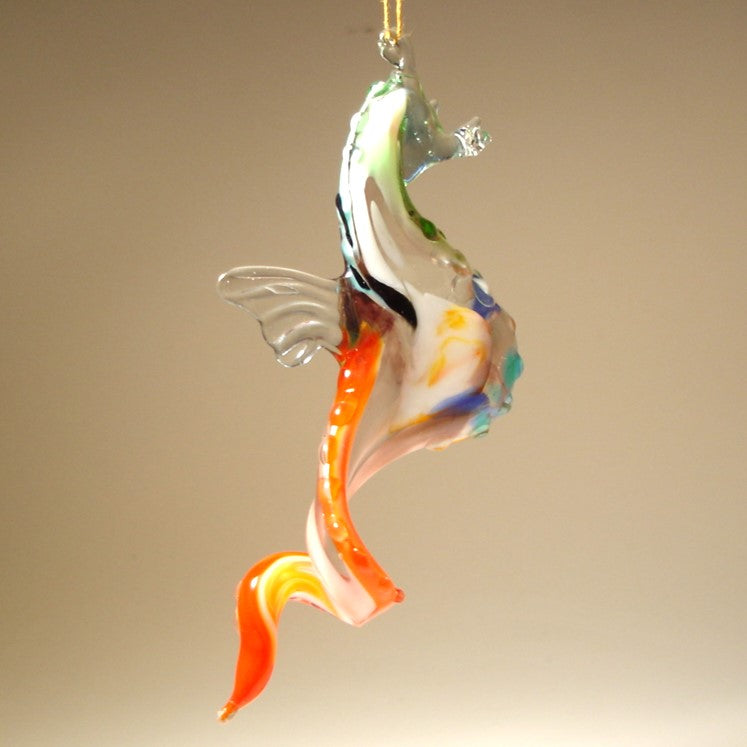 Another side view of the glass hanging seahorse ornament, showcasing its red and white colors and curled tail.