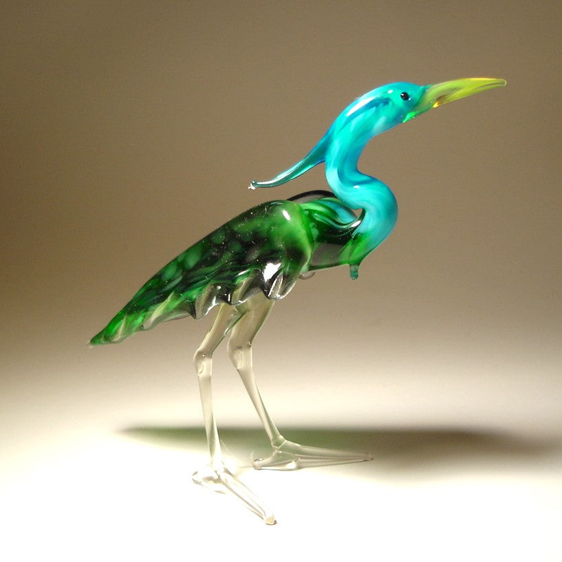 Side view of the glass heron figurine, highlighting the detailed green wings and slender legs.