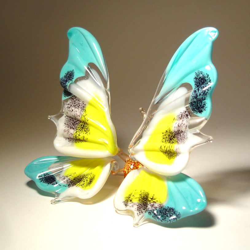 The blue, yellow and white glass butterfly turned to the right
