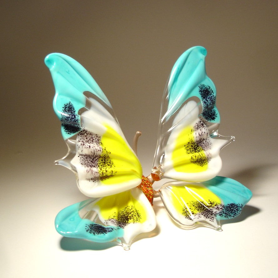 The blue, yellow and white glass butterfly turned to the left