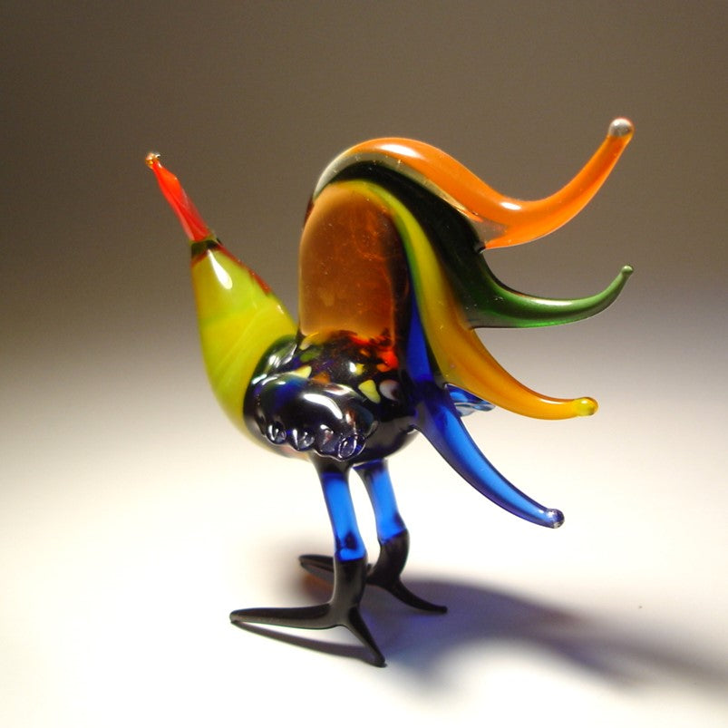 A back view of a glass rooster figurine featuring a stunning array of colorful tail feathers and yellow neck.