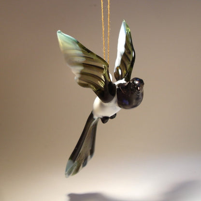 The glass Hanging Bird Magpie figurine ornament displayed from a different angle, highlighting its sleek body and the elegant curve of its tail feathers.