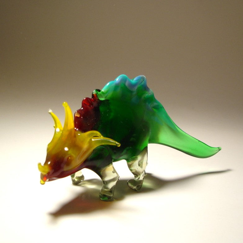 Colorful glass dinosaur figurine on a beige background
