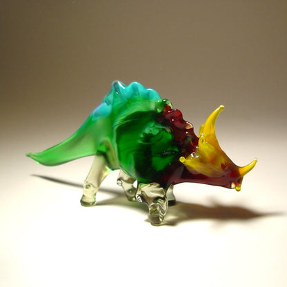 Blown glass triceratops figurine with green, red, and yellow colors