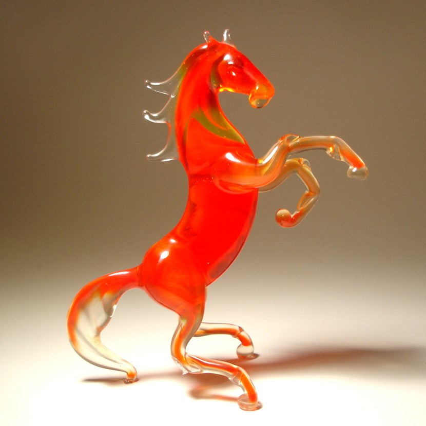 A front view of a red glass horse figurine rearing on its hind legs, showcasing its raised front legs and arched neck.
