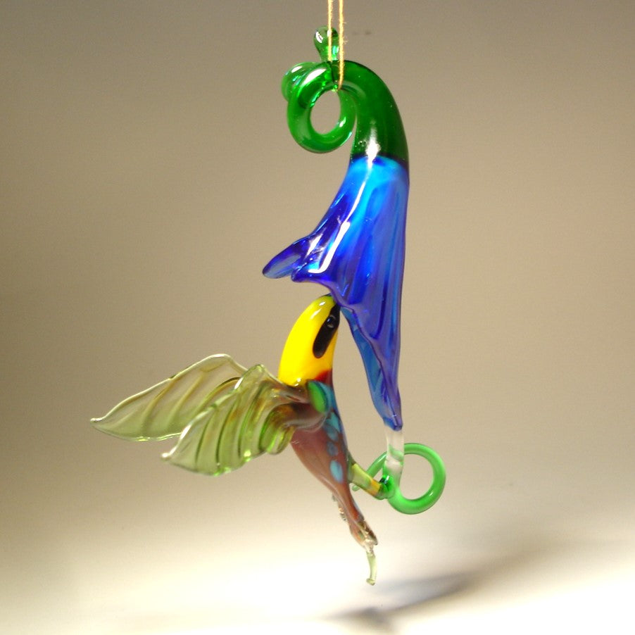 The other view of the blue trumpet flower and green and yellow hummingbird with a red head