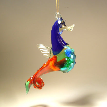 The hanging seahorse ornament is shown from a different view with its red and green curved tail.