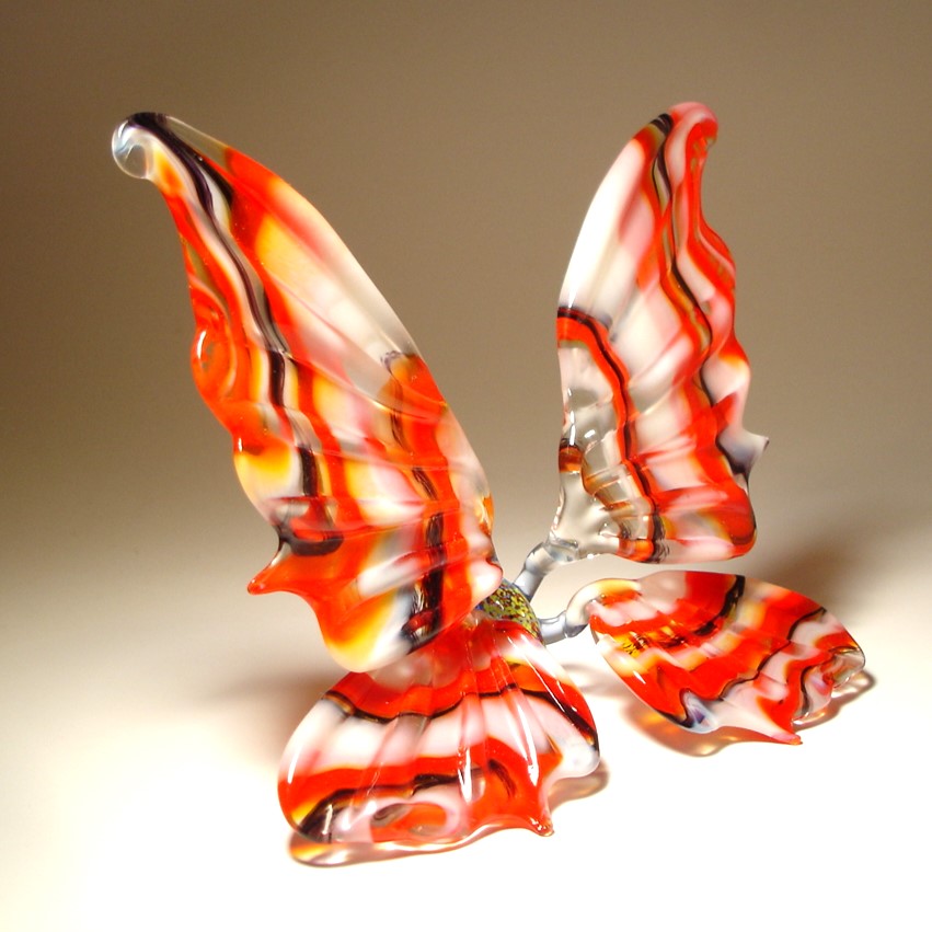 Handmade glass butterfly with red, white and black stripes.