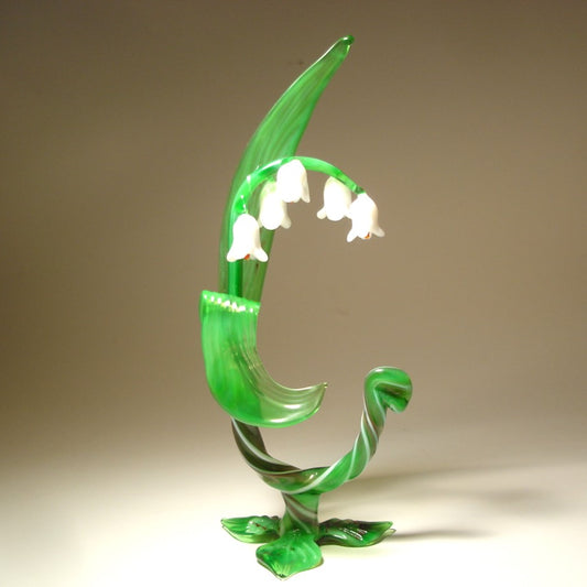 A delicate glass Lily of the Valley flower figurine, showcasing its slender stem, green leaves  and white bell-shaped flowers.