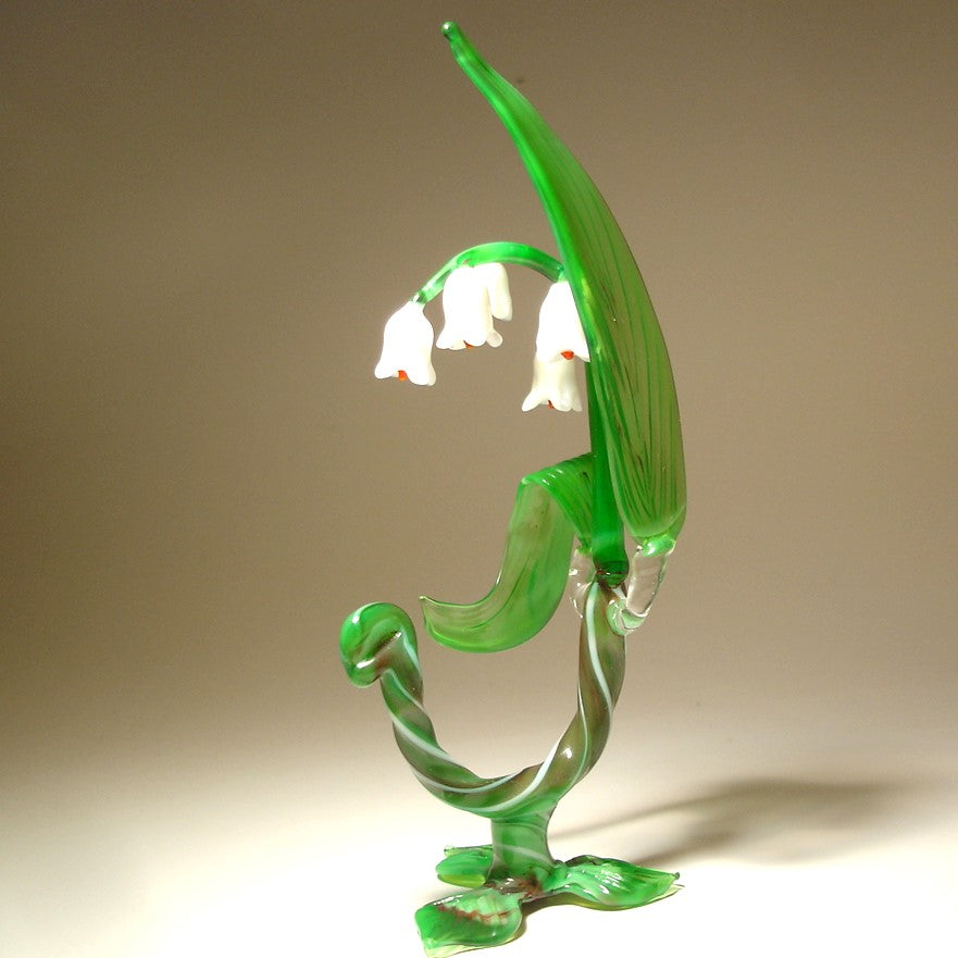 A side view of the glass Lily of the Valley flower figurine, capturing its graceful curves and the arrangement of flowers along the stem.