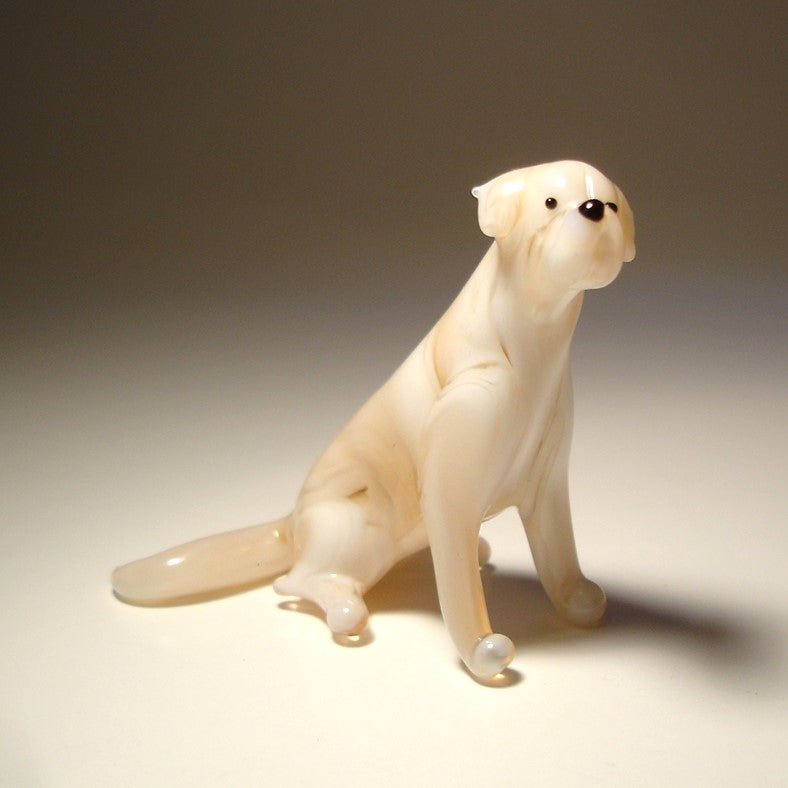 A glass Yellow Lab figurine is shown from the side, showcasing its sturdy build, strong legs, and  tail.