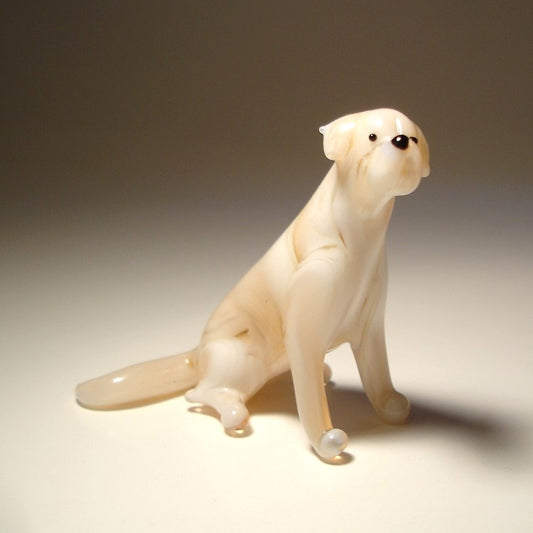 A glass Yellow Lab figurine is shown from the side, showcasing its sturdy build, strong legs, and  tail.