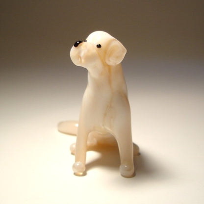 A handcrafted glass Yellow Labrador Retriever figurine sits gracefully, featuring the breed's smooth beige coat and friendly expression.