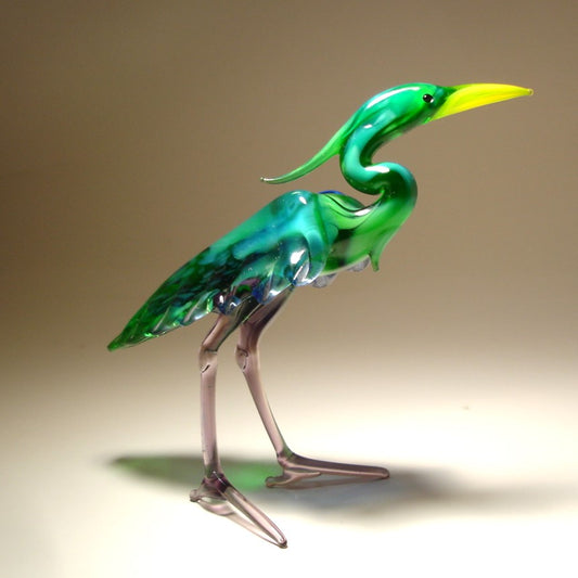 A back view of the glass heron figurine highlighting its green-blue back and intricate feathers on the side of its body.