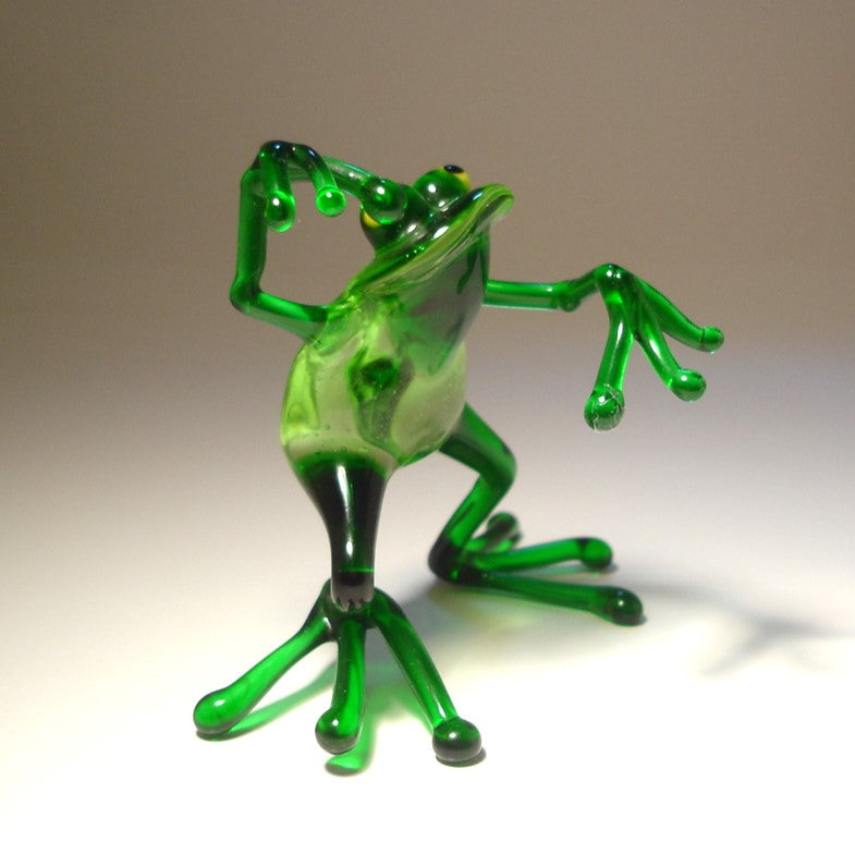 Handmade glass frog figurine in a dancing pose, with one leg slightly lifted and arms gracefully extended.