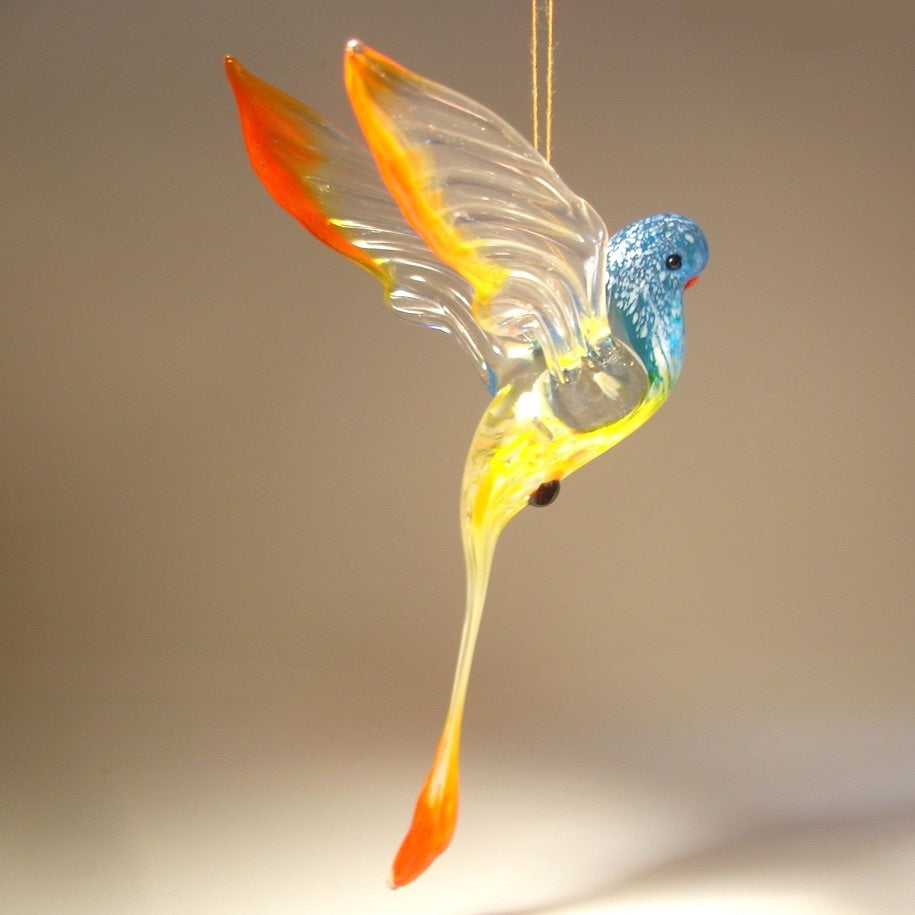 A colorful glass Hanging Blue & Red Parrot Parakeet ornament, gracefully suspended, showcasing its vibrant blue and red feathers.