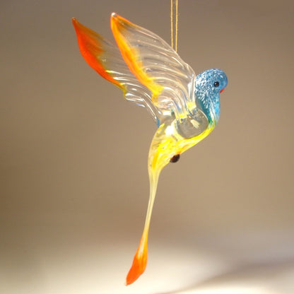 A colorful glass Hanging Blue & Red Parrot Parakeet ornament, gracefully suspended, showcasing its vibrant blue and red feathers.