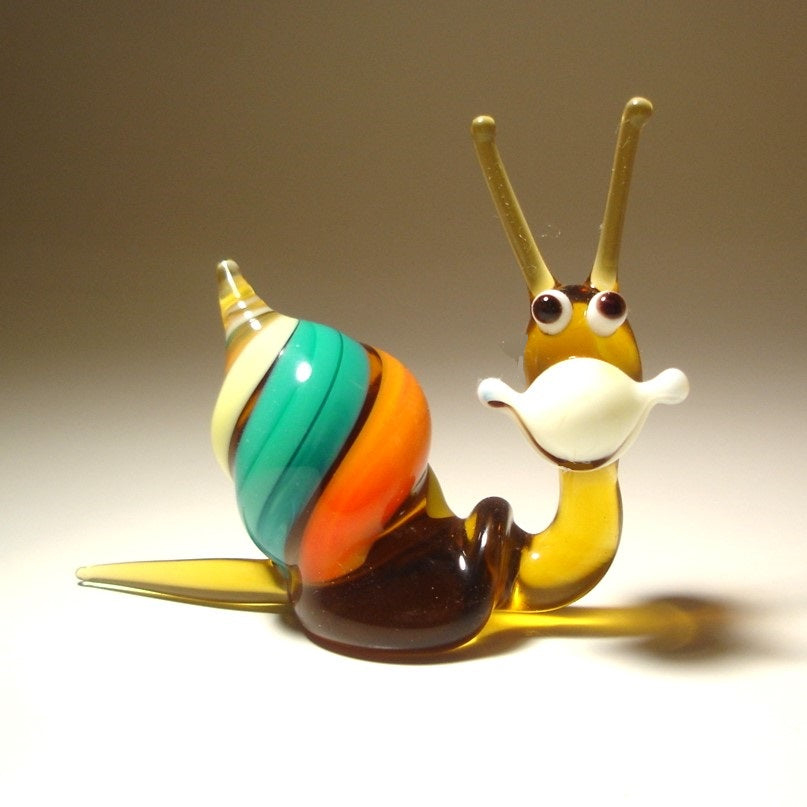 A close-up of a comical Glass Happy Snail Figurine smiling.
