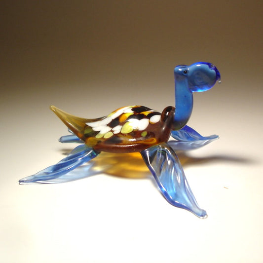 glass blue sea turtle figurine with white and yellow  specs on its shell