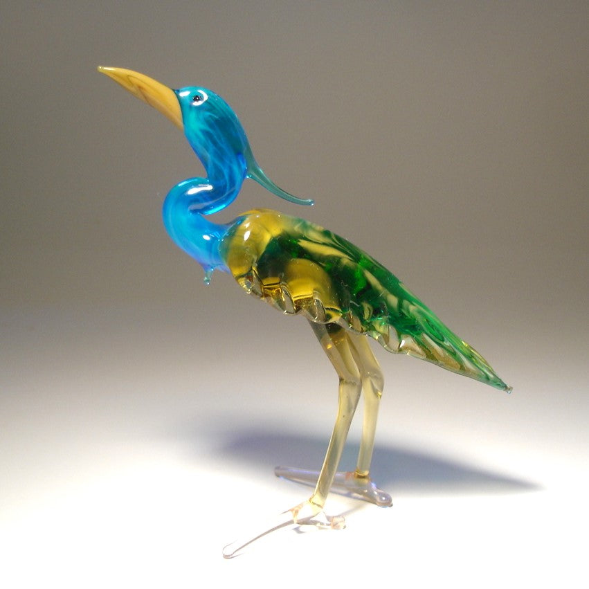 Side view of the glass heron figurine, highlighting the detailed green wings and slender legs.